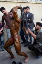 Un bodybuilder afghan s'échauffe avant une compétition à Kabouk, le 18 avril 2018