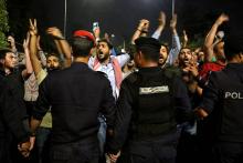 Des protestataires font face à des policiers lors d'une manifestation contre un projet de loi fiscal devant le bureau du Premier ministre le 1er juin 2018 à Amman