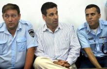 Photo prise le 22 avril 2004 dans un tribunal de Tel-Aviv montrant un ancien ministre de l'Energie et des Infrastructures, Gonen Segev (C), condamné à de la prison pour trafic de drogue