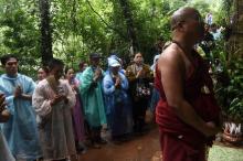 Un moine bouddhiste et des familles des enfants coincés dans une grotte prient à Chiang Rai, le 27 juin 2018