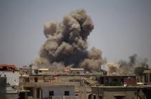 De la fumée s'élève au-dessus d'un quartier tenus par les rebelles, à la suite d'un bombardement du régime syrien sur la ville de Basr al-Harir, dans l'est de la province de Deraa (sud)