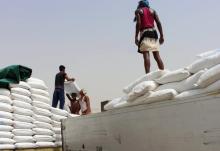 Des Yéménites déchargent des sacs d'aide alimentaire à destination des déplacés de la province de Hodeida, dans la province de Hajja, contrôlée par les Houthis, le 22 juin 2018