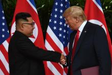 Le leader nord-coréen Kim Jong Un (g) serre la main au président américain Donald Trump (d) avant le début du sommet historique à l'hôtel Capella, le 12 juin 2018 à Singapour
