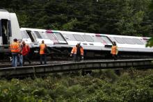 Des employés de la SNCF près d'un RER qui a déraillé entre Saint-Rémy-les-Chevreuse et Courcelle-sur-Yvette le 12 juin 2018