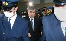 Junichi Fukuda, vice-ministre administratif du ministère japonais des Finances, escorté par des policiers, le 16 avril 2018 à Tokyo