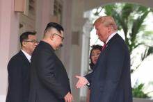 Le président américain Donald Trump et le dirigeant nord-coréen Kim Jong Un signent des documents lors de leur sommet à Singapour, sur une photographie prise le 12 juin 2018 et diffusée le lendemain p