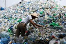 Un Vietnamien fait le tri de bouteilles en plastique usagées dans une décharge de Hanoi le 4 juin 2018