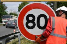 Un employé de la Direction interdépartementale des routes (DIR) installe un panneau de limitation de vitesse à 80 km/h sur une route nationale, le 28 juin 2018 à Grenade