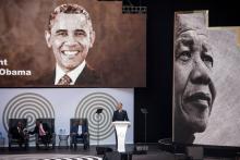Les portraits de Nelson Mandela et de Barack Obama sur une affiche à l'entrée du stade Wanderers, le 17 juillet 2018 à Johannesburg, où l'ancien président américain prononcera un discours, point d'org
