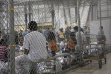 Des enfants et des adultes ayant traversé la frontière illégalement, attendent au centre de rétention McAllen au Texas, le 17 juin 2018