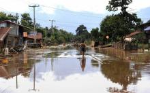 Des habitants retournent chez eux après les inondations provoquées par l'effondrement d'un barrage le 26 juillet 2018 à Sanamxai, dans la province laotienne d'Attapeu