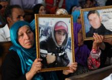 Des familles de victimes de la révolution tunisienne contre la dictature brandissent des portraits des personnes tuées lors d'un procès à Kasserine, dans le centre-ouest de la Tunisie, le 13 juillet 2
