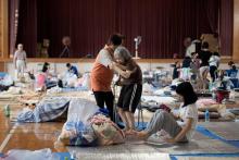 Une dame âgée est aidée dans un refuge pour les victimes des inondations à Mabi, dans la préfecture d'Okayama, le 11 juillet 2018
