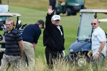 Le président américain Donald Trump (c) sur le parcours de golf de son luxueux complexe hôtelier de Turnberry, le 14 juillet 2018 en Ecosse