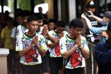 Les jeunes footballeurs rescapés avec leur entraîneur d'une grotte en Thaïlande arrivent pour donner une conférence de presse à leur sortie de l'hôpital, le 18 juillet 2018
