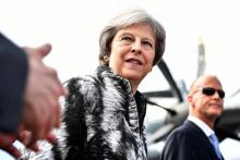 La Première ministre britannique Theresa May (C) arrive au salon de Farnborough, dans le sud-ouest de Londres, accompagnée du patron d'Airbus Tom Enders (D), le 16 juillet 2018