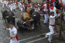 Des taureaux piétinent un participant aux fêtes de San Fermin à Pampelune dans le nord de l'Espagne, le 14 juillet 2018
