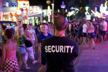 Un agent de sécurité privé en faction au milieu des touristes, le 18 juillet 2014 à Calvia, aux Iles Baléares