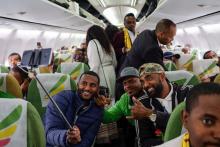Des passagers se sourient à bord de l'avion des Ethiopian Airlines reliant Addis Abeba à Asmara, en Erythrée, le 18 juillet 2018.