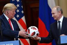 Le président russe Vladimir Poutine offre un ballon du Mondial au président américain Donald Trump, lors d'une conférence de presse commune, le 16 juillet 2018 à Helsinki