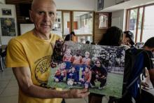 L'entraîneur du Ménival Football Club Alain Gonnard pose avec une photo de Samuel Umtiti lorsque le défenseur des Bleus évoluait au club, le 12 juillet 2018 à Lyon