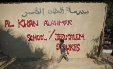 Un enfant palestinien longe un mur de l'école de Khan al-Ahmar, le jour de la rentrée scolaire, le 16 juillet 2018, en Cisjordanie occupée