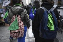 Des élèves arborent sur leurs sacs à dos un foulard vert, symbole de la lutte pour le droit à l'avortement, dans une rue de Buenos Aires le 5 juillet 2018