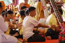 Les jeunes footballeurs et leur entraîneur rescapés d'une grotte en Thaïlande participent à une cérémonie dans un temple bouddhiste le 19 juillet 2018 au lendemain de leur sortie de l'hôpital