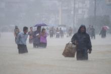 Des habitants de la ville de Pégou en Birmanie dans les rues inondées de leur ville, le 29 juillet 2018