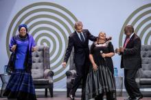 L'ex président américain Barack Obama, la veuve de Nelson Mandela, Graça Machel (à gauche) et le président sud-africain Cyril Ramaphosa (à droite) dansent en compagnie de la chanteuse Thandiswa Mazwai
