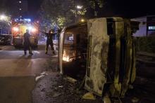 Des policiers près d'une voiture brûlée dans le quartier du Breil à Nantes le 4 juillet 2018 au petit matin
