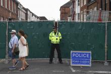 Un policier montant la garde le 5 juillet 2018 devant une barrière interdisant l'accès à une rue d'Amesbury, dans le sud de l'Angleterre, où un couple a été hospitalisé dans un état critique après avo
