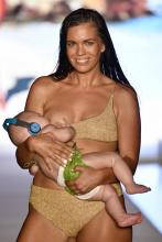 La mannequin américaine Mara Martin défile en allaitant son bébé, Aria, à Miami le 15 juillet 2018