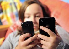 Une jeune fille envoie des SMS depuis un téléphone portable, le 08 octobre 2009.