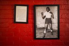 Un cliché noir et blanc de Nelson Mandela en tenue de boxeur et une copie de la lettre qu'il écrivit à sa fille Zindzi depuis le bagne de Robben Island accrochés au mur d'un gymnase de Soweto, le 11 j
