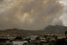 La fumée s'élève au-dessus de Kineta, près d'Athènes, en proie à un feu de forêt le 23 juillet 2018.