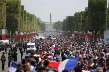 Un camion de pompiers pris d'assaut par des supporters en liesse après le succès de la France en finale du Mondial, le 15 juillet 2018 sur les Champs-Elysées