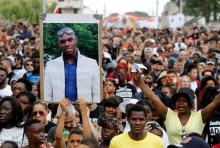 Une personne tient un portrait lors d'une marche, le 21 juillet 2018 à Paris, à la mémoire d'Adama Traoré, décédé il ya deux ans à la suite de son interpellation