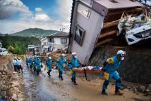 Des secouristes le 9 juillet 2018 dans une rue de Kumano, frappée par les pluies meurtrières qui ont dévasté l'ouest du Japon