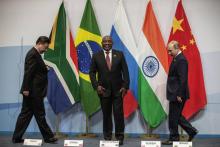 Le président chinois Xi Jinping (à gauche) et son homologue russe Vladimir Poutine (à droite) avec le président sud-africain Cyril Ramaphosa au sommet des BRICS le 26 juillet 2018 à Johannesburg.