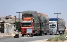 Des camions chargés de marchandises attendent d'être contrôlés au point de passage de Morek, entre les zones du régime à Hama et celles contrôlées par les jihadistes et rebelles dans la province d'Idl