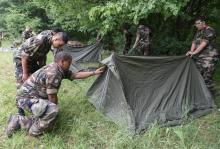 Des jeunes du Service militaire volontaire (SMV) plantent leur tente dans une forêt près de Rozérieulles (Moselle) le 10 juillet 2018