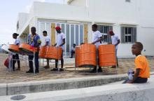 Des tambours pour célébrer un projet de réfection des toits de maisons détruites par la tempête Irma, le 12 juillet 2018 à Codrington, sur l'île de Barbuda