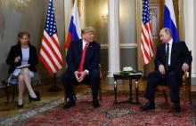 Sur cette photo du 16 juillet 2018, l'interprète Marina Gross se trouve aux côtés des présidents américain Donald Trump et russe Vladimir Poutine à Helsinki