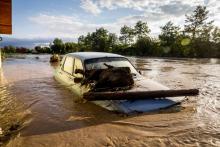 Une voiture au milieu d'une route inondée dans le village de Bacel, dans le département de Covasna, dévasté par les intempéries, le 1er juillet 2018