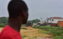Un Ivoirien observe le site de l'accident d'un hélicoptère des forces françaises en Côte d'Ivoire, à Abidjan le 11 juillet 2018