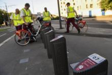 Des salariés viennent changer les vélos en libre service dans une station à Villeurbanne près de Lyon, le 17 juillet 2018
