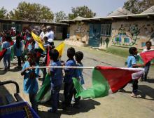 Des enfants palestiniens brandissent le drapeau palestinien lors d'une manifestation le 1e août 2018 à Khan al-Ahmar, un village de Bédouins palestiniens près de Jérusalem menacé de destruction par Is