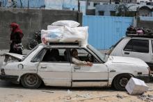 Des Palestiniens transportent en voiture les aides reçues dans un centre de distribution de l'ONU dans le camp de réfugiés de Jabaliya dans le nord de la bande de Gaza, le 8 août 2018