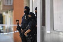 La police catalane monte la garde près d'un immmeuble où vivait un homme qui a attaqué un commissariat à Cornella près de Barcelone, le 20 août 2018